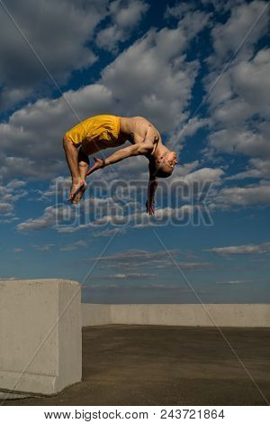 Tricking On Street. Martial Arts And Elements Of Parkour. Man Flips Back Barefoot. Shooted From Bott