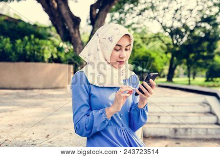 Muslim girl using a smartphone in the park