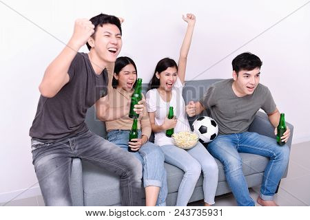 Concept Of Cheering. Asian Teenagers Watching Football On Television. People Are Cheering And Winnin
