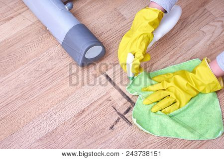 A Picture Of Hands In Yellow Gloves Cleaning The Floor.