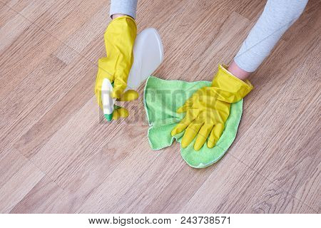 A Picture Of Hands In Yellow Gloves Cleaning The Floor.