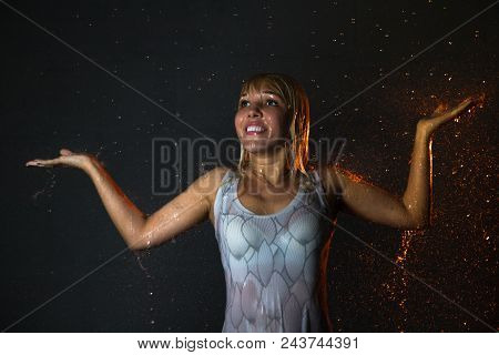 Nice Girl In The White Shirt And Water Drops Behind And Arround Her Illuminated By Light During A Ph