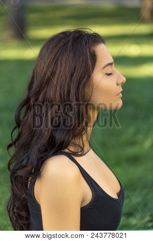 Close-up Profile Portrait Of Fitness Girl. Young Girl Doing Yoga In The Park. Woman Practicing Yoga 
