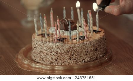Male Hand Lighting Candles In Birthday Cake. Close Up. Professional