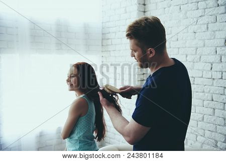 Young Single Father Combs Hair Of Red Haired Daughter At Home. Fatherhood. Relation.