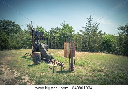 Vintage Tone Working Pump Jack Pumping Crude Oil At Oil Drilling Site In Rural Usa
