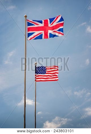 British And American Flags On Flagpoles With Blue Skies On A Sunny Day
