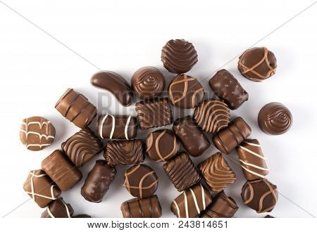 Beautiful Creative Chocolate Sweets Isolated On White Background. Scattered Chocolates Top View And 