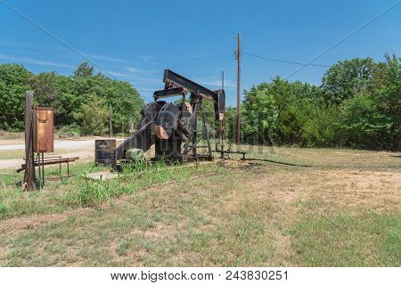 Working Pump Jack Pumping Crude Oil At Oil Drilling Site In Rural Usa