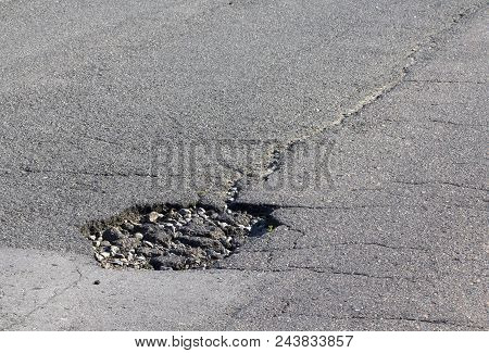 There Are Many Potholes On The Roadway Close-up