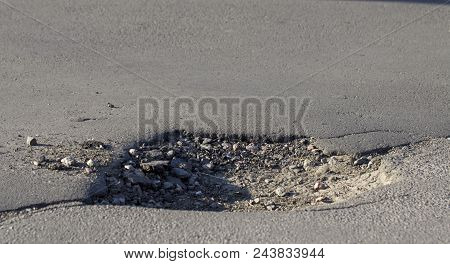 There Are Many Potholes On The Roadway Close-up