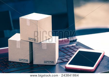 Online Shopping Concept E-commerce Delivery Buying Service. Square Cartons Shopping On Laptop Keyboa