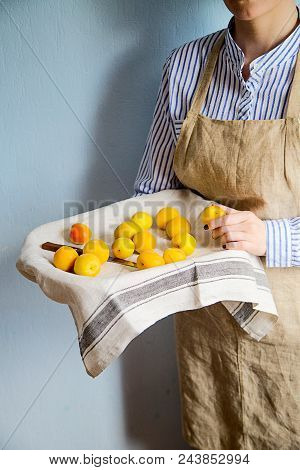 A Man Is Holding A Tray Fukk Of Fresh Apricots And Peaches From The Garden.