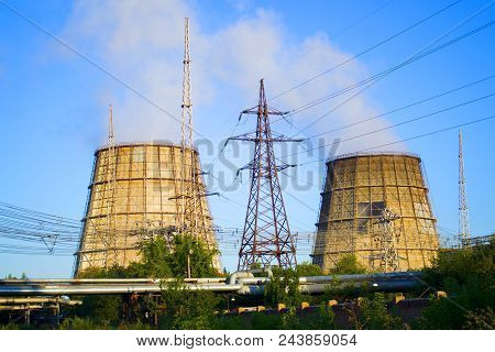 Two Cooling Pipes, Power Lines And Pipes With Hot Water, Clear Blue Sky