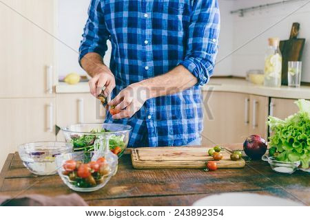 Man Cooking Healthy Simple Vegetarian Food At Home In The Kitchen Sunny Evening. Healthy Food Concep