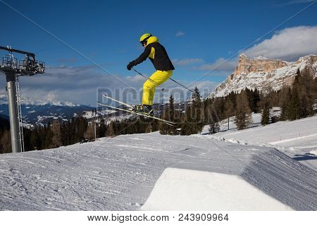 Skier In Action: Ski Jumping In The Mountain Snowpark.