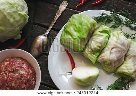 Cabbage Roll On The White Plate. Raw Minced Pork With Beef In Cabbage Green Leaves, Red Chili Pepper