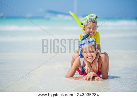 Brother And Sister In Scuba Masks Playing And Having Fun On The Beach During The Hot Summer Vacation