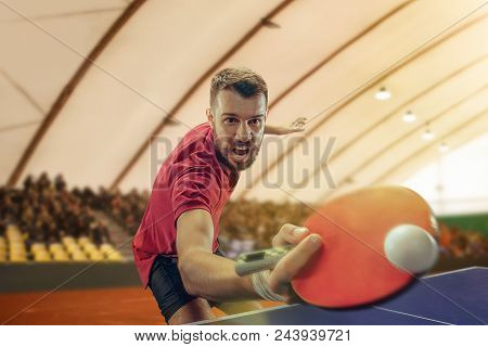 The Table Tennis Player In Motion. Fit Young Sports Man Tennis-player In Play On Sport Arena Backgro