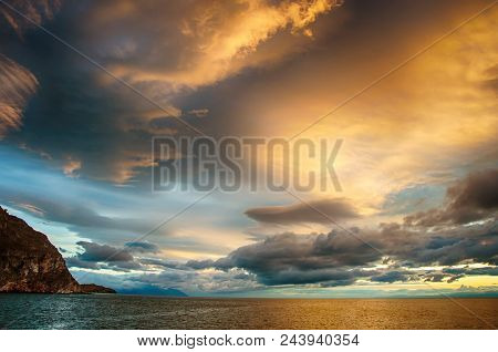Sunset Over Stormy Clouds Across The Water Reflecting Dark And Looming Dramatic Sky Moody Feeling Of