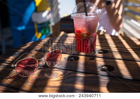 Refreshing Cocktail On A Wooden Table With Sunglasses