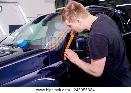 A Man Is Polishing A Blue Car. Polishing Machine And Polishing Paste For Gloss.