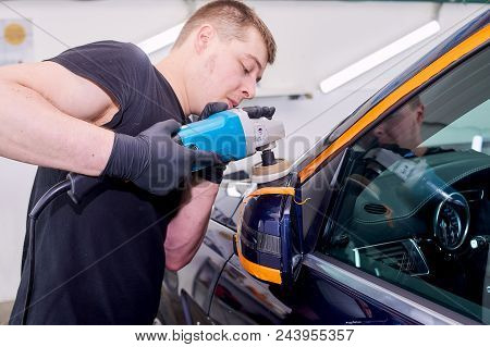 A Man Is Polishing A Blue Car. Polishing Machine And Polishing Paste For Gloss.