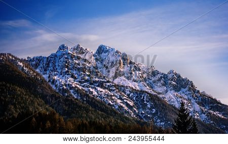 Mountain Peak Surrounded In Clouds, Skrlatica Mountain In The Evening Glow From Kranjska Gora Ski Re