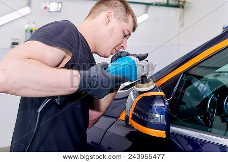 A Man Is Polishing A Blue Car. Polishing Machine And Polishing Paste For Gloss.