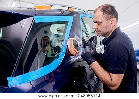 A Man Is Polishing A Blue Car. Polishing Machine And Polishing Paste For Gloss.