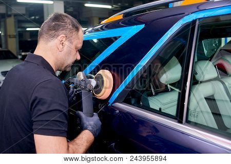 A Man Is Polishing A Blue Car. Polishing Machine And Polishing Paste For Gloss.