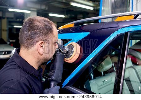 A Man Is Polishing A Blue Car. Polishing Machine And Polishing Paste For Gloss.