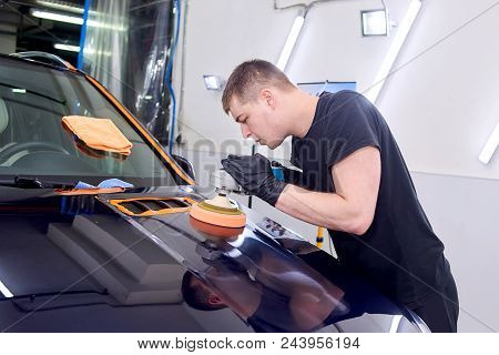 A Man Is Polishing A Blue Car. Polishing Machine And Polishing Paste For Gloss.