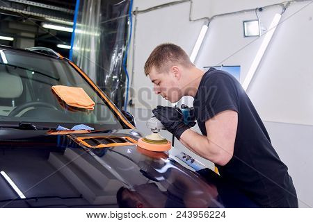 A Man Is Polishing A Blue Car. Polishing Machine And Polishing Paste For Gloss.