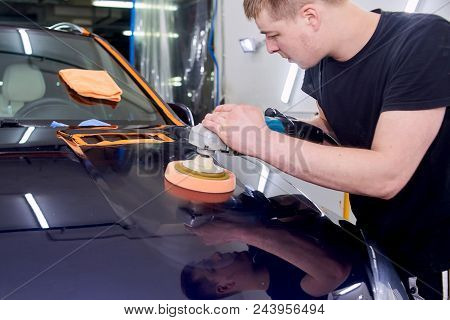 A Man Is Polishing A Blue Car. Polishing Machine And Polishing Paste For Gloss.