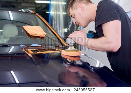 A Man Is Polishing A Blue Car. Polishing Machine And Polishing Paste For Gloss.