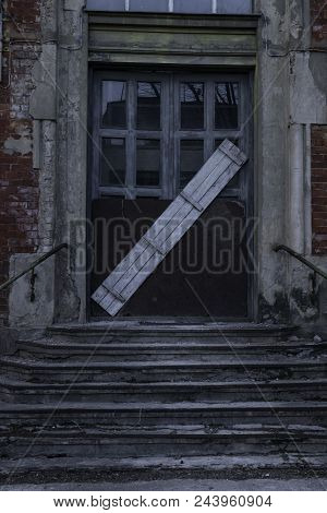 Old Wooden Door All Boarded Up And Old Ladder In Dark Fear Evening. Closed Door With Wooden Board Ba