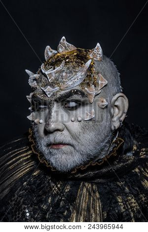 Demon With Golden Collar On Black Background. Man With Thorns Or Warts, Face Covered With Glitters. 
