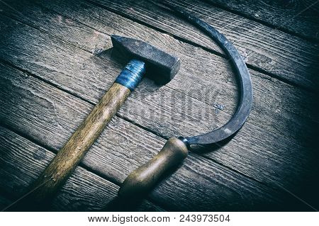 Old Hammer And Sickle Lying On Wooden Board Background