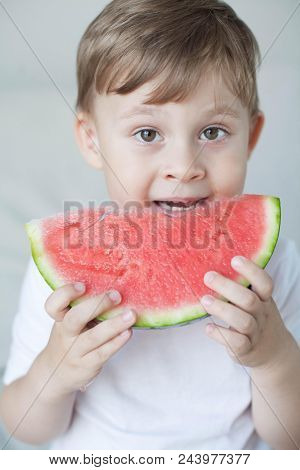 A Small Cute Boy 4 Years Old Is Eating A Watermelon. Summer. Heat. Watermelon. Portrait Of A Happy B