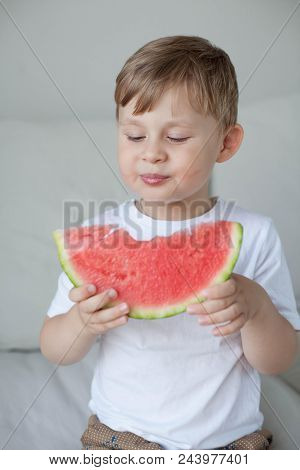 A Small Cute Boy 4 Years Old Is Eating A Watermelon. Summer. Heat. Watermelon. Portrait Of A Happy B