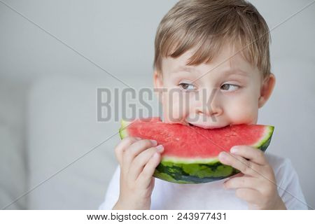 A Small Cute Boy 4 Years Old Is Eating A Watermelon. Summer. Heat. Watermelon. Portrait Of A Happy B