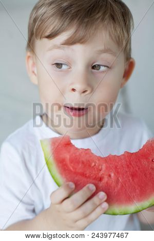 A Small Cute Boy 4 Years Old Is Eating A Watermelon. Summer. Heat. Watermelon. Portrait Of A Happy B