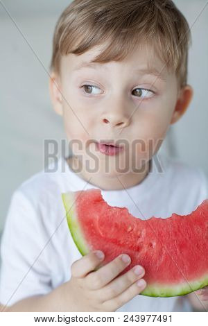 A Small Cute Boy 4 Years Old Is Eating A Watermelon. Summer. Heat. Watermelon. Portrait Of A Happy B
