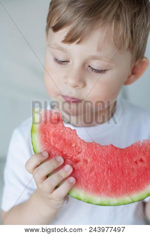 A Small Cute Boy 4 Years Old Is Eating A Watermelon. Summer. Heat. Watermelon. Portrait Of A Happy B