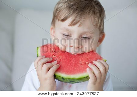 A Small Cute Boy 4 Years Old Is Eating A Watermelon. Summer. Heat. Watermelon. Portrait Of A Happy B