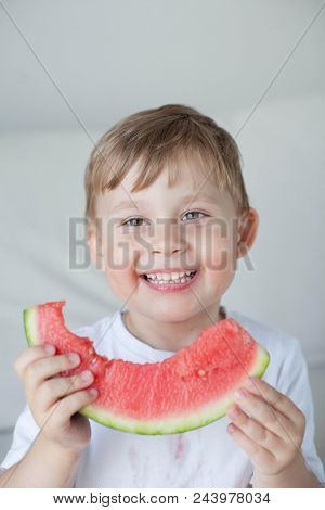 A Small Cute Boy 4 Years Old Is Eating A Watermelon. Summer. Heat. Watermelon. Portrait Of A Happy B