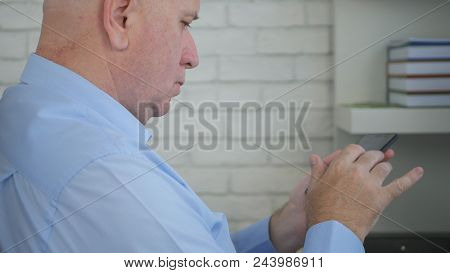 Confident Businessman Accessing Online Information Using Cell Phone