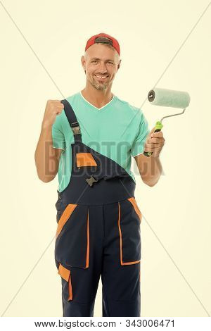 Decorator Creative Work. Paint And Renovate. Decorator Painting Wall. Man In Cap Hold Paint Roller W