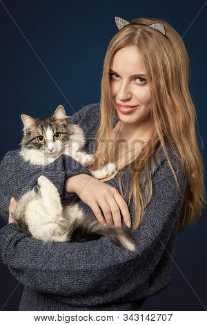 Happy Girl With Cat On Dark Blue Background Looking At Camera, Smiling